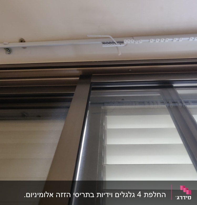 תריסים לבנים עם מסגרת מתכתית בחלון